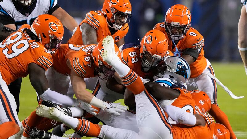 Carolina Panthers running back Chuba Hubbard is tackled by a group of Chicago Bears defenders...